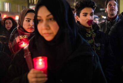 Un grupo de personas guardan homenajean a las víctimas del atentado en Berlín junto a la iglesia Gedächtniskirche.