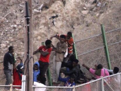 Moroccan police beat immigrants at the border fence on July 18.