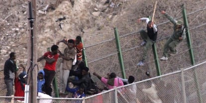 A la derecha, agentes marroqu&iacute;es bajan de la valla a palos a subsaharianos.