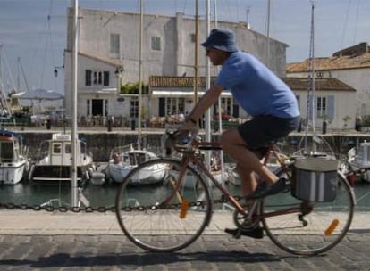 Un ciclista circula por el puerto de Saint Martin de Ré, centro neurálgico de la isla francesa de Ré.