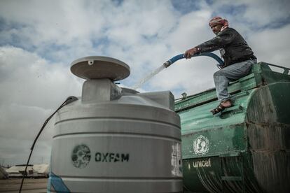 Un técnico de Oxfam Intermón recargando un tanque de agua en el campo de Zaatari.