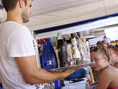 Un camarero sirve a un grupo de turistas en un restaurante en la Alcudia, Mallorca.
