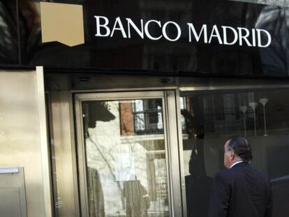 Un hombre frente a la sede de Banco Madrid.