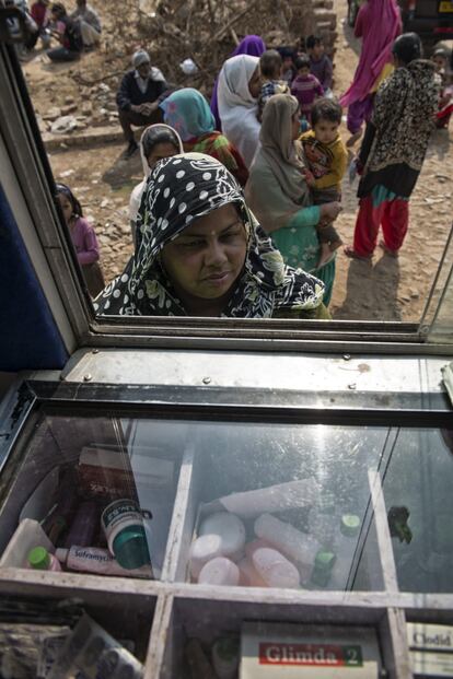 Una paciente espera en la ventanilla delantera del autobús de Nueva Delhi para recoger la medicación prescrita. "Lo más difícil es hacer entender a la gente qué y cuándo tiene que tomar", reconoce el farmacéutico. Todo el tratamiento es gratuito.