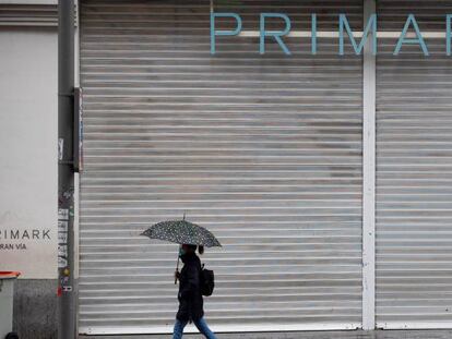 Una mujer pasa ante una tienda de ropa ubicada en la Gran Vía