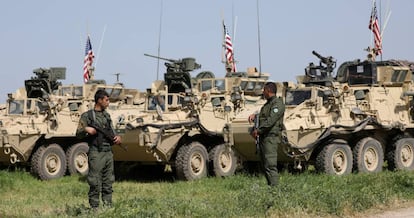 Milicianos curdos junto a veículos militares dos EUA na localidade síria de Darbasiya, perto da fronteira com a Turquia, em 2017.