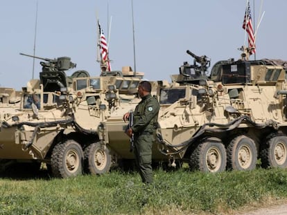 Milicianos curdos junto a veículos militares dos EUA na localidade síria de Darbasiya, perto da fronteira com a Turquia, em 2017.
