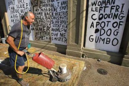 Un comerciante de Nueva Orleans, Bob Rue, limpia una alfombra oriental, dañada por las inundaciones.