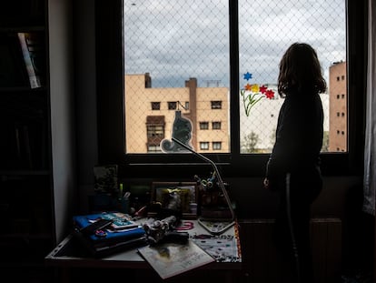 Una niña mira desde su ventana al exterior en Madrid, durante el confinamiento. ÁLVARO GARCÍA