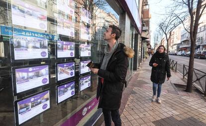 Un joven ante una agencia inmobiliaria en Madrid.