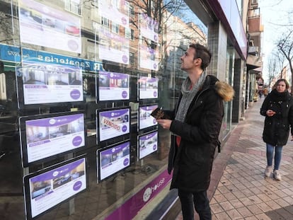 Un joven ante una agencia inmobiliaria en Madrid.