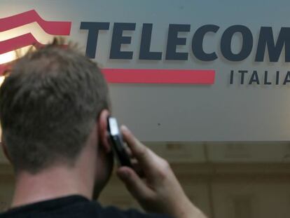 Un usuario habla por m&oacute;vil junto a un logo de Telecom Italia. 