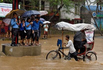 Un grupo de estudiantes universitarios se refugian durante una inundación en Guwahati (India).
