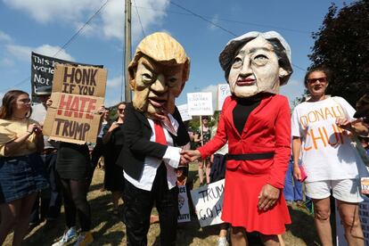 Manifestantes llevan máscaras de Donald Trump y Theresa May para protestar por la visita del presidente estadounidense, a las afueras de Chequers.