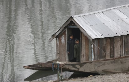 Dos niños de Cachemira observan desde un bote el funeral de los rebeldes adolescentes Saqib Bilal Sheikh y Mudasir Rashid Parray en la aldea de Hajin, al norte de Srinagar (Cachemira), controlada por India.