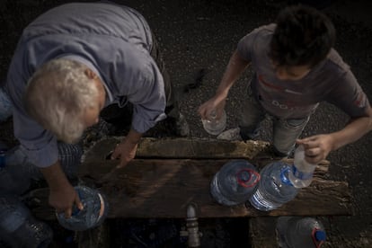 Un niño y un hombre recogen agua en una fuente pública en el municipio de Byblos, al norte de Beirut. Según datos de la ONU, más del 75% de los niños libaneses no alcanzan los niveles nutricionales necesarios. Los precios de los víveres crecieron más del 400% en un año y medio.