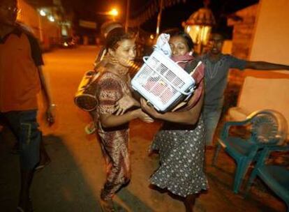 Una mujer salva sus pertenencias en Colombo después de que el Gobierno de Sri Lanka alertase a la población.