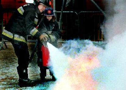 Un bombero enseña a un niño a apagar un incendio durante el simulacro de ayer.