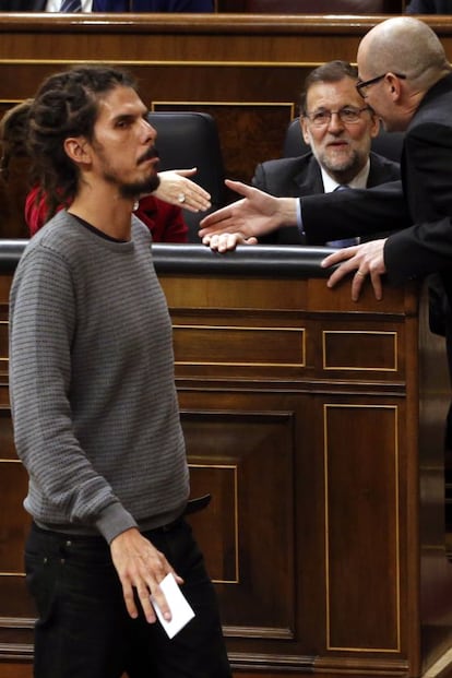 Podemos Deputy Alberto Rodríguez (left) walks by acting Prime Minister Mariano Rajoy.