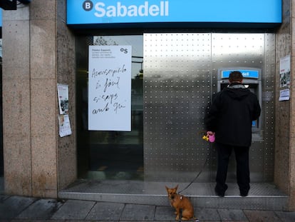 Un cliente opera en uno de los cajeros automáticos de Banco Sabadell, en una imagen de archivo.