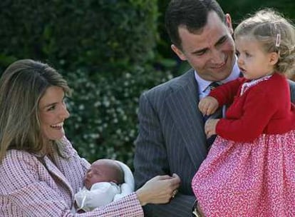 La princesa Letizia, con su hija Sofía, juega con la infanta Leonor, en brazos del príncipe Felipe.