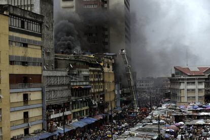 Bomberos tratan de extinguir un incendio en un mercado de Lagos (Nigeria).