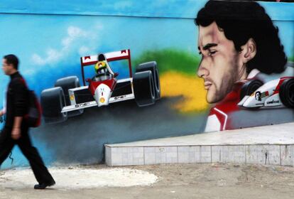 Un hombre camina entre graffitis del piloto de Fórmula 1 Ayrton Senna, en el 20 aniversario de su muerte, en Sao Paulo 1 de mayo 2014.