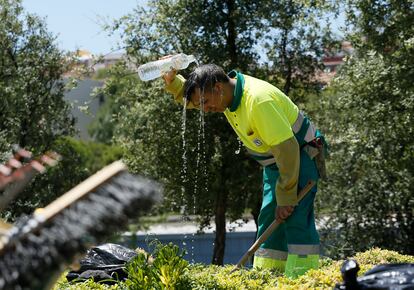 Un jardinero de Madrid se refresca durante una ola de calor veraniega.