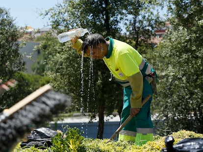 Un jardinero de Madrid se refresca durante una ola de calor veraniega.