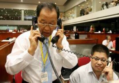 Dos agentes de bolsa trabajan en la Bolsa de Filipinas en el distrito financiero de Makati. EFE/Archivo