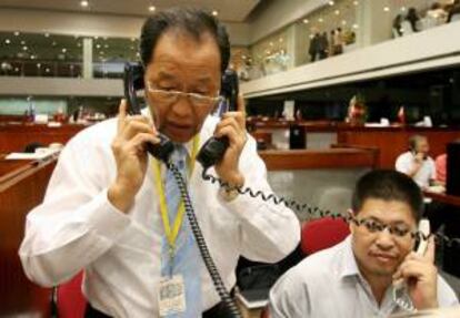 Dos agentes de bolsa trabajan en la Bolsa de Filipinas en el distrito financiero de Makati. EFE/Archivo