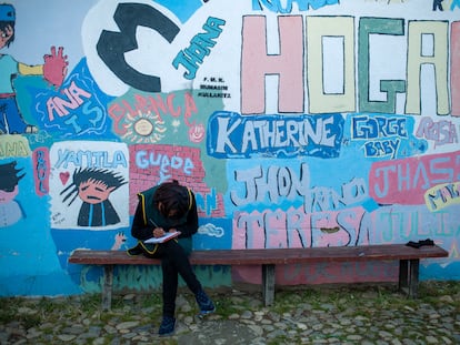 Una joven sentada frente al mural de un hogar de acogida en Bolivia para niñas y adolescentes víctimas de trata.