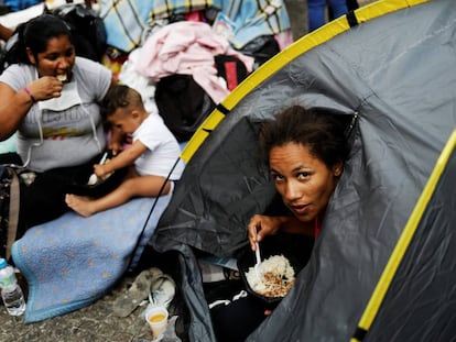 Mulher almoça no acampamento montado para receber moradores de prédio que caiu, em São Paulo.