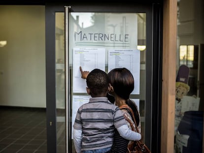 Una mujer busca información sobre la nueva clase de su hijo, en una escuela maternal en Lyon (Francia), en 2014.