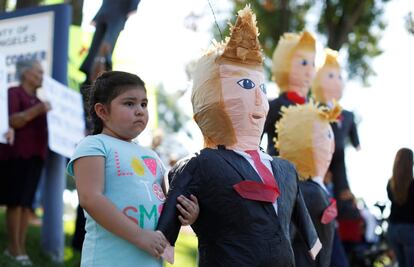 Emily Alonso, de 4 años, sujeta una piñata con la imagen del candidato republicano a la Casa Blanca, Donald Trump en Norwalk, California (Estados Unidos).