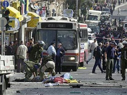 La policía israelí examina el cadáver del terrorista, tendido en el suelo con una sábana.