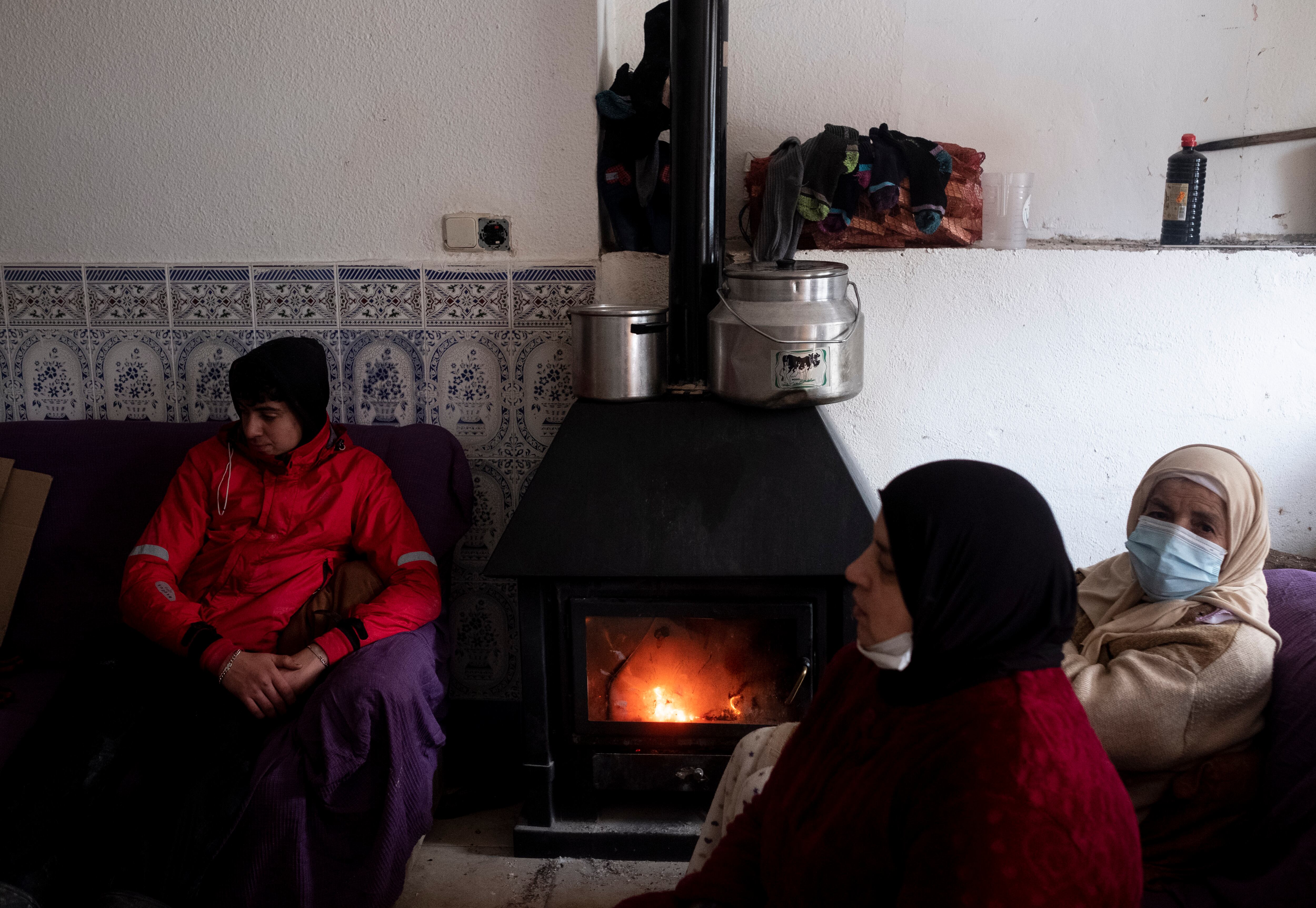 La familia Najah se calienta con una chimenea de madera en el interior de su casa de la Cañada Real.