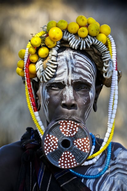 La cámara se adentra en una de las zonas más pobres de Etiopía, de difícil acceso: la cuenca del río Omo. Aquí conviven algunas de las mas emblemáticas tribus de África. Pueblos indígenas como los mursi, al que pertenece la mujer de la foto.