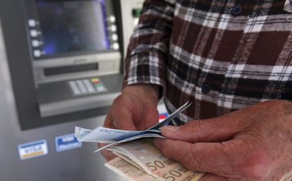 Un hombre saca dinero de un cajero automático.
