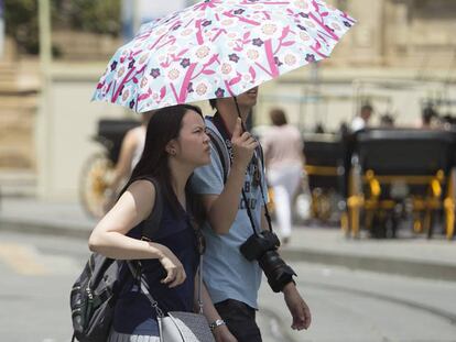 Dos turistas pasean por el centro de Sevilla.