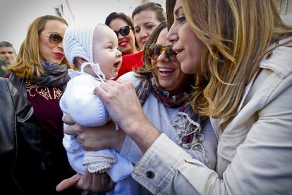 Susana Díaz (d), haciendo carantoñas a un bebé en La Algaba (Sevilla), en un acto de la campaña electoral socialista, el 10 de marzo de 2015.