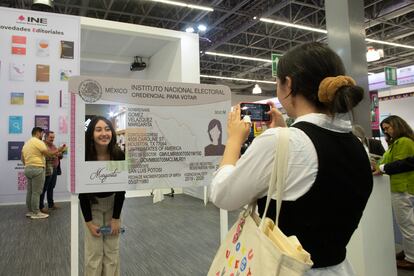 Una joven se toma fotografías en el stand del Instituto Nacional Electoral; uno de los temas que abordan las mesas de dialogo político en la FIL es la propuesta de reforma electoral por parte del gobierno de México. 