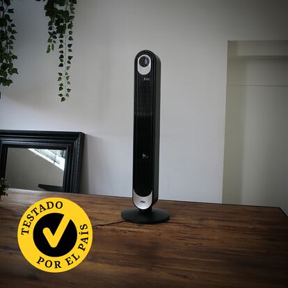 Un ventilador de torre encima de una mesa de madera.