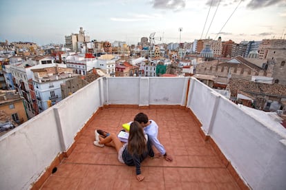 Una pareja de jóvenes, en una azotea del casco histórico de València, una imagen de la fotoperiodista Mònica Torres, incluida en la colección de libros.