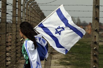 Una mujer sostiene una bandera de Israel durante la llamada "Marcha por la vida", que realiza un recorrido desde el antiguo campo de concentración de Auschwitz I hasta el campo de Auschwitz II-Birkenau, en Oswiecim (Polonia), el 16 de abril de 2015.