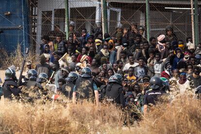 Agentes de la policía antidisturbios acordonan el área después de que los migrantes llegaran a suelo español y cruzasen las vallas que separan Melilla de Marruecos, el 24 de junio. 