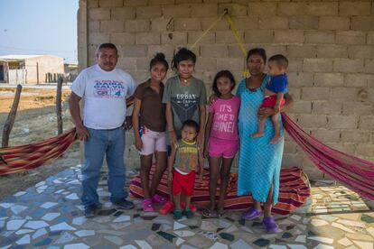 Alexander Jesús González y su esposa, Floricia González, con algunos de sus siete hijos en el porche de su casa en Uribia, La Guajira (Colombia). 