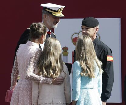 Los Reyes, junto a la princesa Leonor y la infanta Sofía, conversan al final del acto con el paracaidista que descendía con la bandera de España y que se quedó enganchado en una farola.