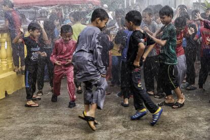 Un grupo de niños musulmanes son rociados con agua antes de una ceremonia de circuncisión masiva en Sungai Pangsun (Malasia).