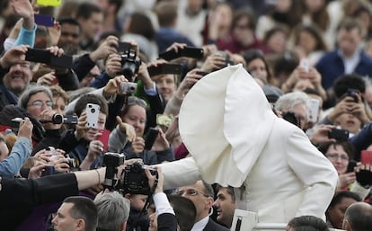 Una ráfaga de viento levanta el manto del Papa Francisco a su llegada a la audiencia general del miércoles en la plaza de San Pedro en el Vaticano.